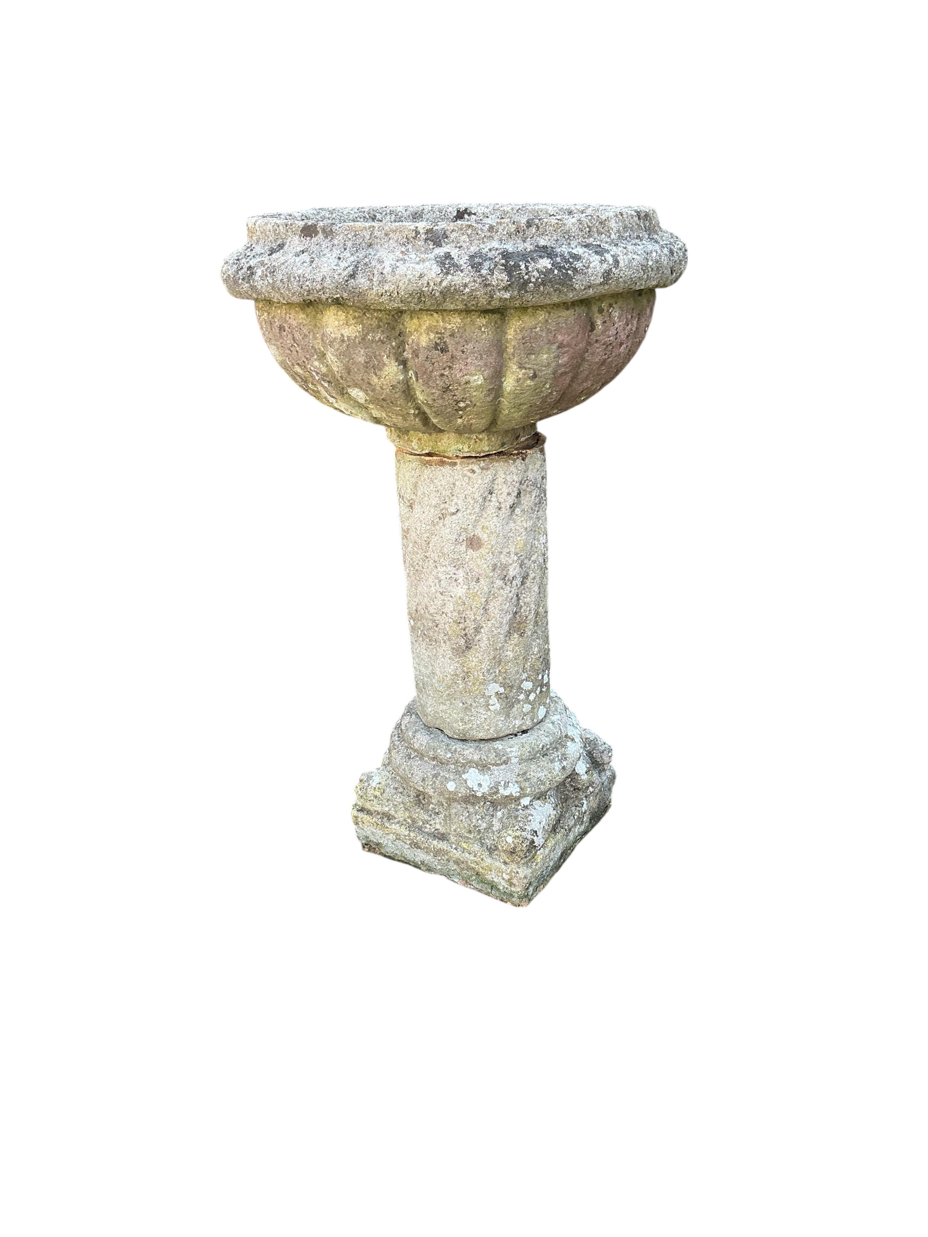 A reconstituted stone garden planter, diameter 54cm, height 90cm